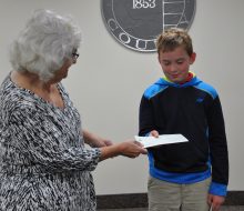 Toni Drier looks on as Melinda Spencley presents Jack Robinson with check for first place award of $100.